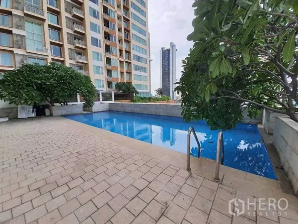 Condominium for rent or sale in Sathon, Bangkok - Condominium swimming pool with landscaped deck, trees, and city views beside the residence.