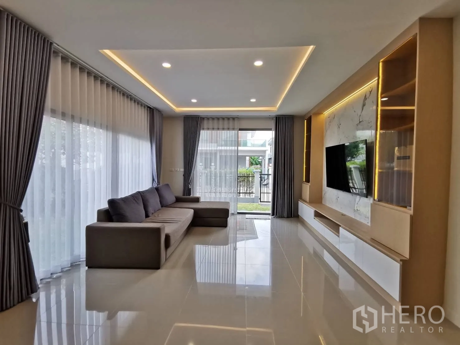 บ้านเดี่ยว for rent in Bang Phli, Samut Prakan - ห้องนั่งเล่นกว้าง โซฟาเข้ามุม หน้าต่างบานใหญ่ และผนังทีวีบิวท์อิน