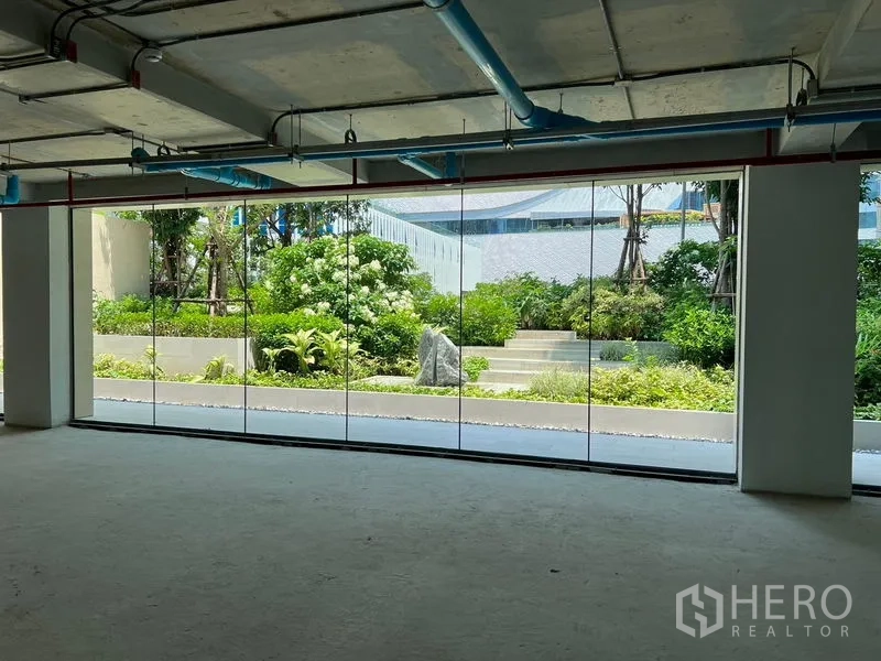 Retail Space for rent in Pathum Wan, Bangkok - Retail interior with glass frontage, garden outlook, and doorway access.