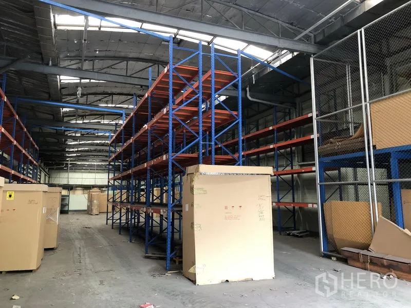 工厂 出租在Lam Luk Ka, Pathum Thani - 金属屋顶下的货架通道，展示充足储存能力。