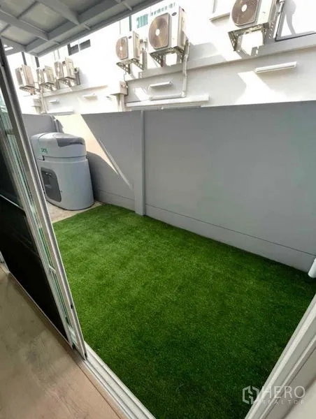 Townhouse for rent in Prawet, Bangkok - Private outdoor patio with artificial grass accessed via sliding glass door.
