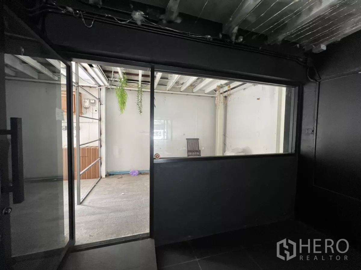 Retail Space for rent in Watthana, Bangkok - Rear section with glass partition opening to a utility or storage room with hanging plants.