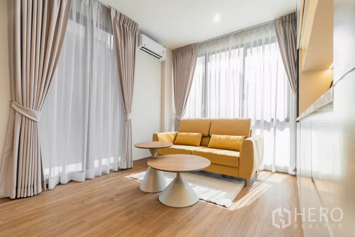 Detached House for rent or sale in Prawet, Bangkok - Upstairs family lounge with yellow sofa, twin coffee tables and sheer curtains