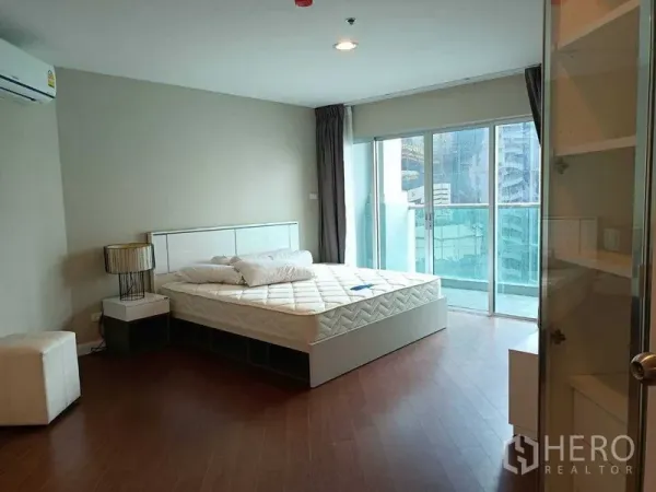คอนโด ให้เช่าหรือขายในHuai Khwang, Bangkok - ห้องนอนมาสเตอร์มีหน้าต่างบานใหญ่ ทางออกสู่ระเบียง และพื้นไม้.