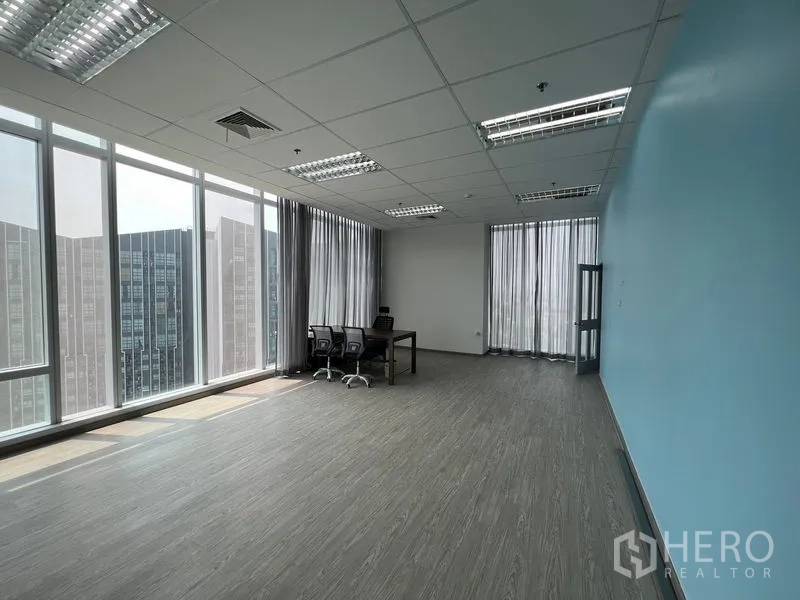 办公空间 出租 - 超大明亮办公室，蓝色强调墙与落地玻璃，城市景观。