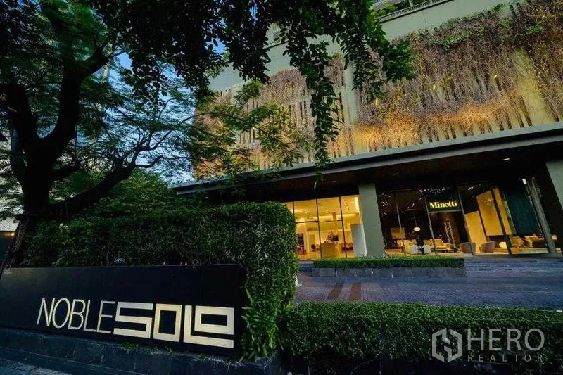 คอนโด ให้เช่าในWatthana, Bangkok - ด้านหน้าอาคารพร้อมล็อบบี้สว่างและป้าย Noble Solo