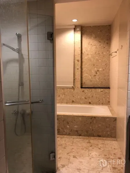 Detached House for rent in Wang Thonglang, Bangkok - Bathroom featuring a glass-enclosed shower and a built-in bathtub with stone tiles.