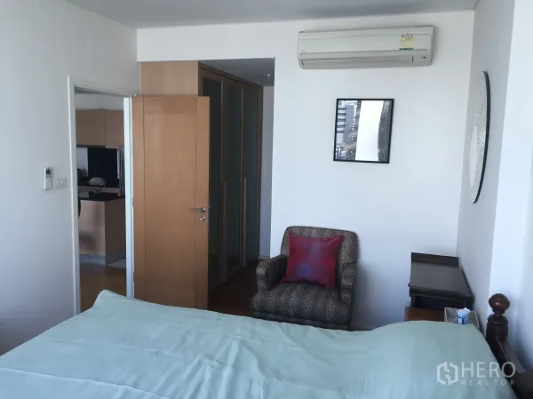 公寓 出租在Watthana, Bangkok - 舒适卧室，配空调、单人沙发与内置衣柜。