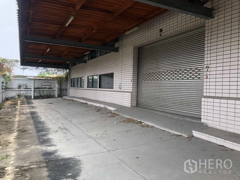Factory for rent in Prawet, Bangkok - Loading dock with roller shutter door and covered canopy.