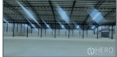 Warehouse for rent in Chon Buri - Spacious warehouse floor with steel column grid, ample skylight panels, and smooth concrete surface.
