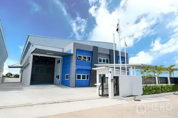 货栈 出租在Bang Bo, Samut Prakan - 仓库前立面，车道宽阔并配绿化围栏。