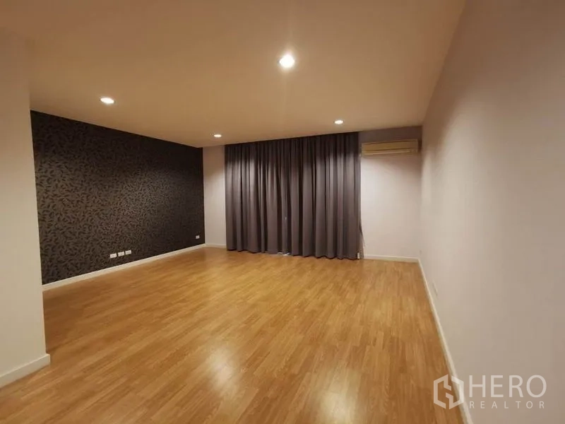 Townhouse for rent in Yan Nawa, Bangkok - Large master bedroom with recessed lighting, feature wall, and blackout curtains.