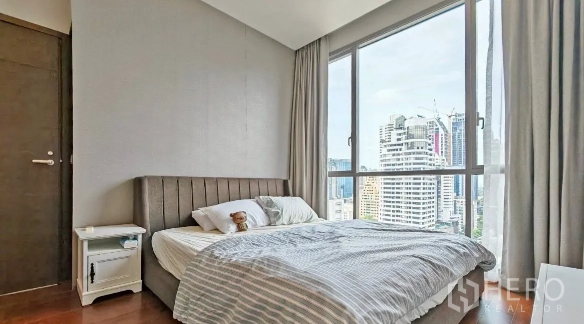 公寓 出租在Watthana, Bangkok - 卧室配大窗、软包床头和床头柜，享宽阔城市天际线景观。