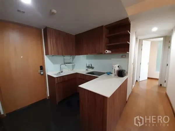 公寓 出售在Watthana, Bangkok - L形厨房，木纹橱柜、白色台面与电器。