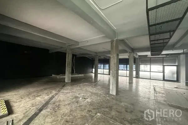 Retail Space for rent - Industrial-style space with multiple pillars, frosted glass panels and wide storefront windows.