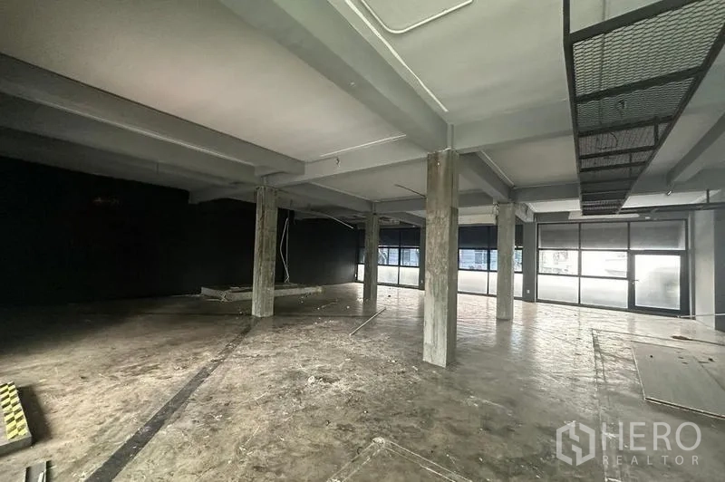 Retail Space for rent - Industrial-style space with multiple pillars, frosted glass panels and wide storefront windows.