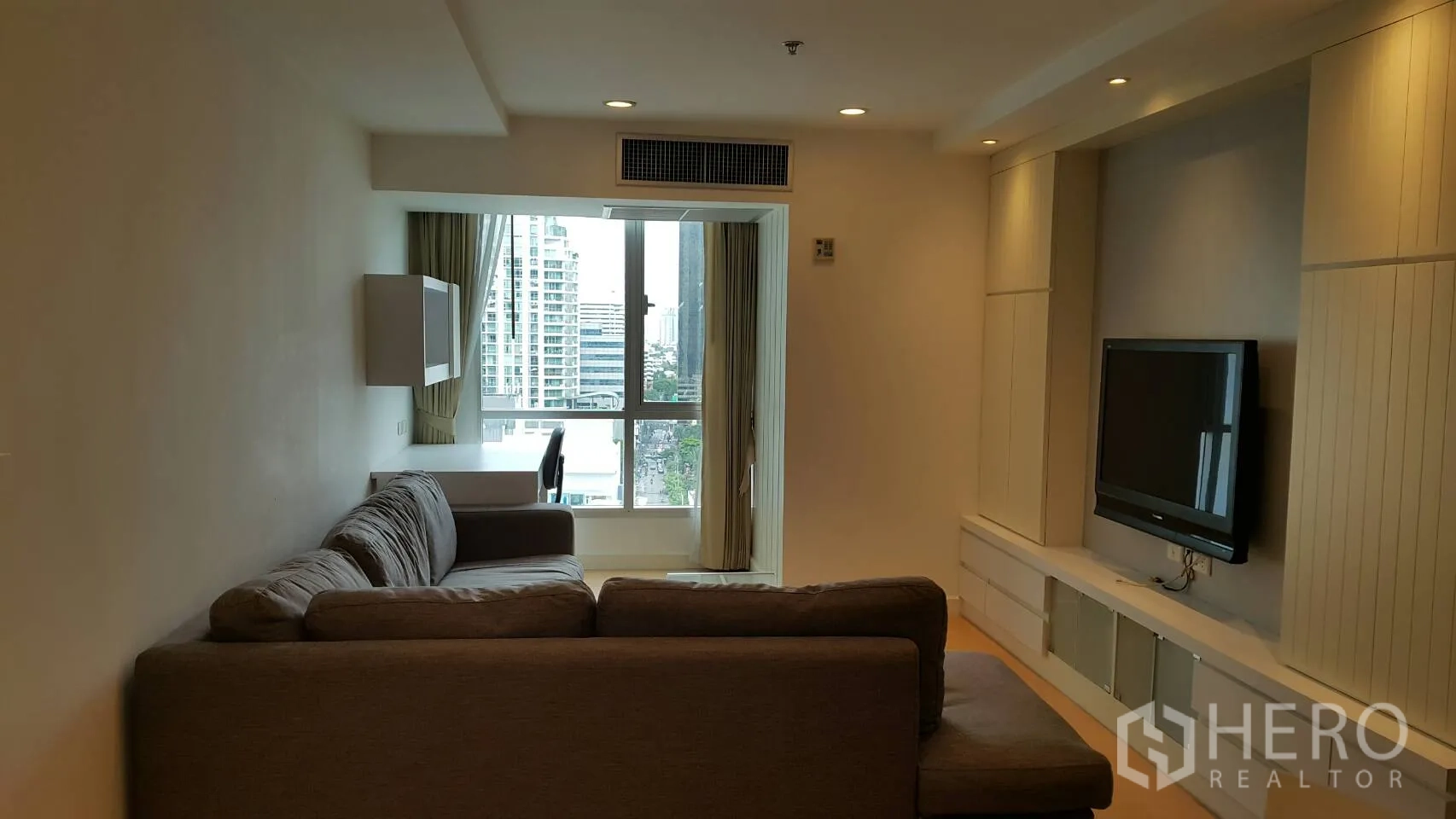 คอนโด ให้เช่าในWatthana, Bangkok - ห้องนั่งเล่นพร้อมโซฟาเข้ามุม ตู้ทีวีบิลท์อิน และหน้าต่างบานใหญ่เห็นวิวเมือง