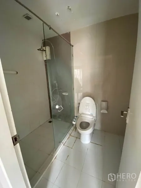 คอนโด ให้เช่าในWatthana, Bangkok - ห้องน้ำสมัยใหม่พร้อมฉากกั้นกระจก โถสุขภัณฑ์ และกระเบื้องโทนสว่าง