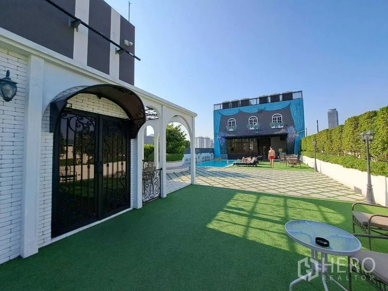 Retail Space for rent in Watthana, Bangkok - Open courtyard with lawn leading to a poolside building and sun deck.