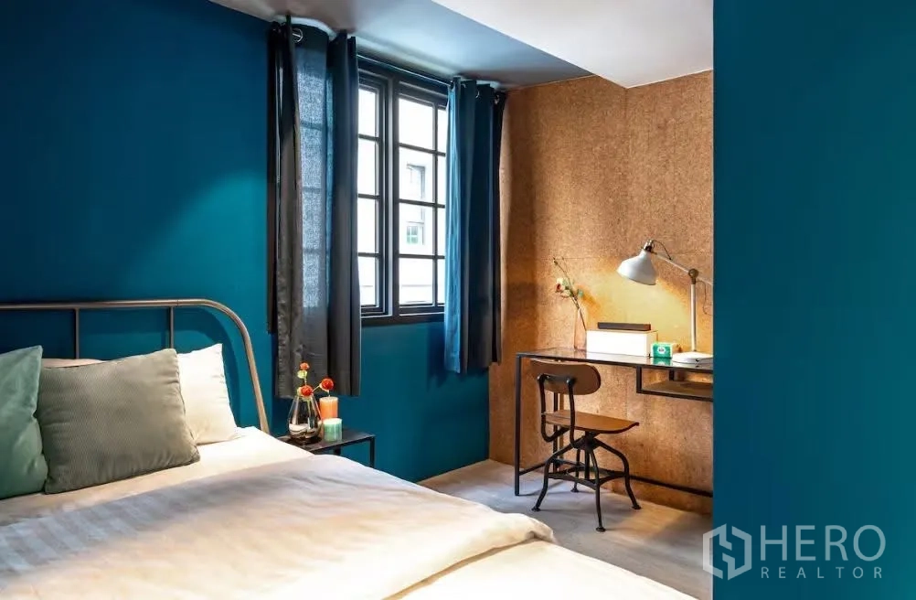 联排别墅 for rent in Watthana, Bangkok - 次卧带书桌与椅子，软木质感特色墙，窗户配窗帘。