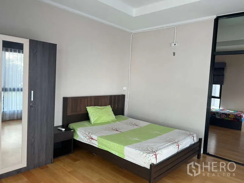 Detached House for rent or sale in Prawet, Bangkok - Guest bedroom with double bed, wardrobe and warm wood flooring.