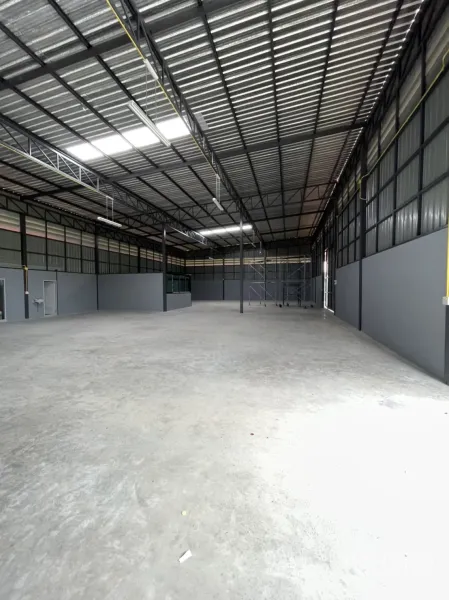 Factory for rent in Khlong Luang, Pathum Thani - Wide shot of empty production floor with skylights and ventilation panels along the walls.