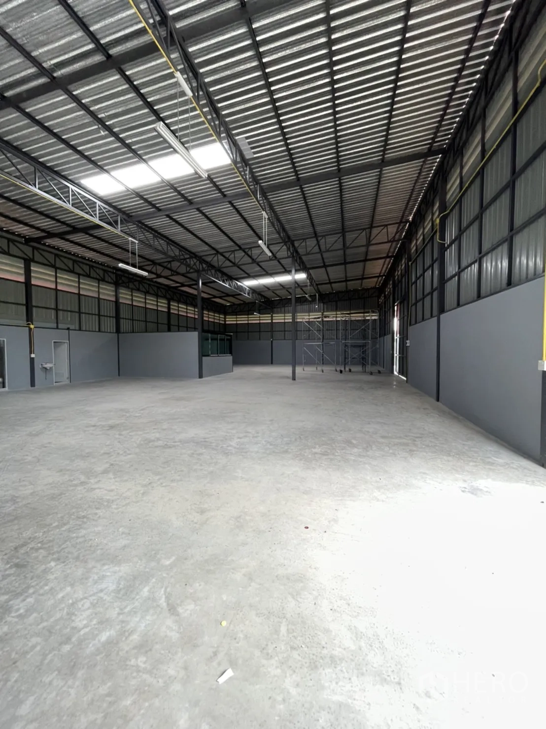 Factory for rent in Khlong Luang, Pathum Thani - Wide shot of empty production floor with skylights and ventilation panels along the walls.
