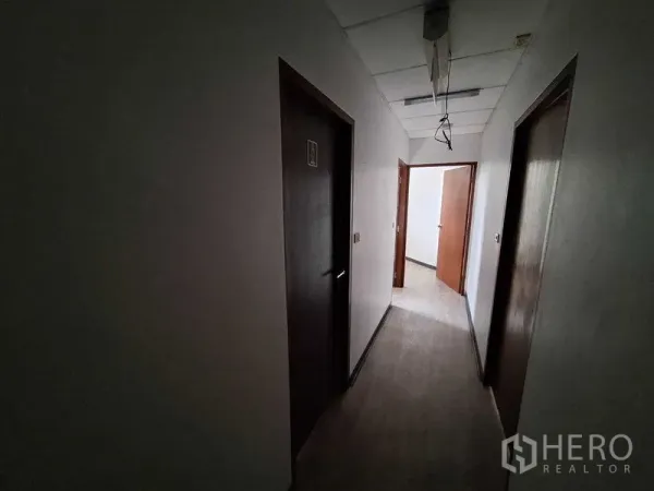 办公空间 出租在Watthana, Bangkok - 昏暗走廊，多扇木门通往独立房间。