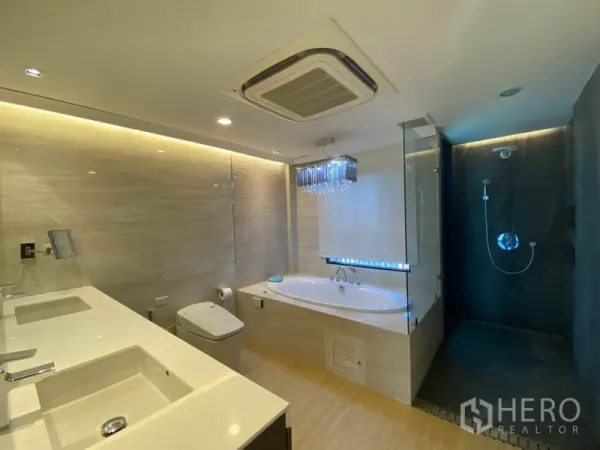 Townhouse for sale in Yan Nawa, Bangkok - Luxury bathroom with double vanity, built‑in bathtub and a separate glass walk‑in shower with dark accent wall.