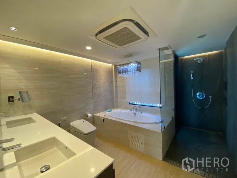 Townhouse for sale in Yan Nawa, Bangkok - Luxury bathroom with double vanity, built‑in bathtub and a separate glass walk‑in shower with dark accent wall.