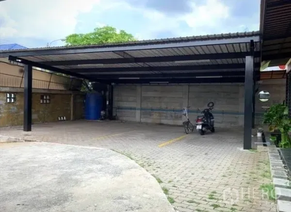 Home Office for rent in Lat Phrao, Bangkok - Wide carport with steel roof, paved surface and marked parking spaces.