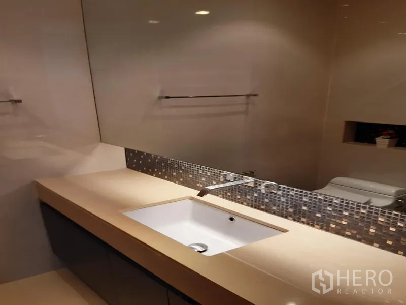 Condominium for rent in Khlong Toei, Bangkok - Modern vanity with under-mount sink, mosaic backsplash and large mirror.