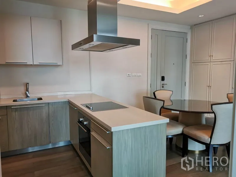 Condominium for rent in Pathum Wan, Bangkok - Fully fitted kitchen with island cooktop, oven and a cozy dining nook.