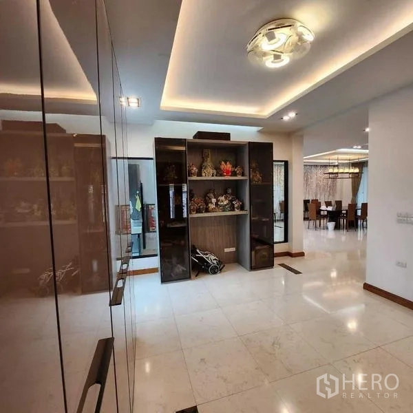 独立式住宅 出售在Phra Khanong, Bangkok - 入户大厅，亮面地砖与展示柜，连接餐厅