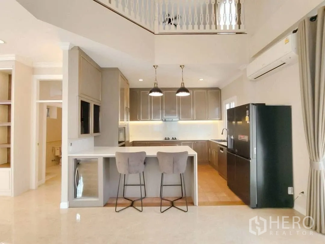 บ้านเดี่ยว for rent in Bang Na, Bangkok - ครัวแบบเปิดมีไอแลนด์บาร์ เก้าอี้สูง และโคมไฟห้อย