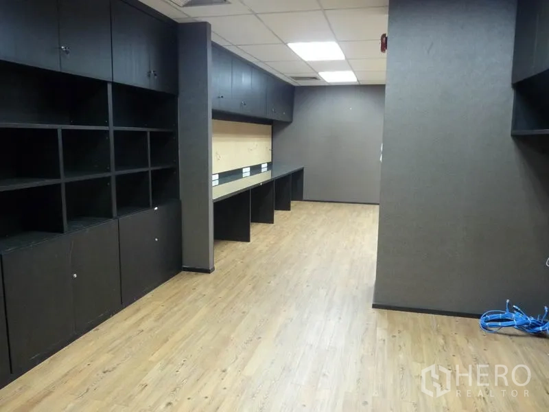 Office Space for sale in Watthana, Bangkok - Workroom featuring long built-in desks, open shelving and wood laminate floors.