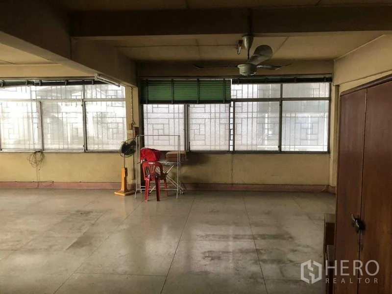 Shophouse for rent in Khlong Toei, Bangkok - Expansive room with a wall of windows, ideal for office or showroom layout.