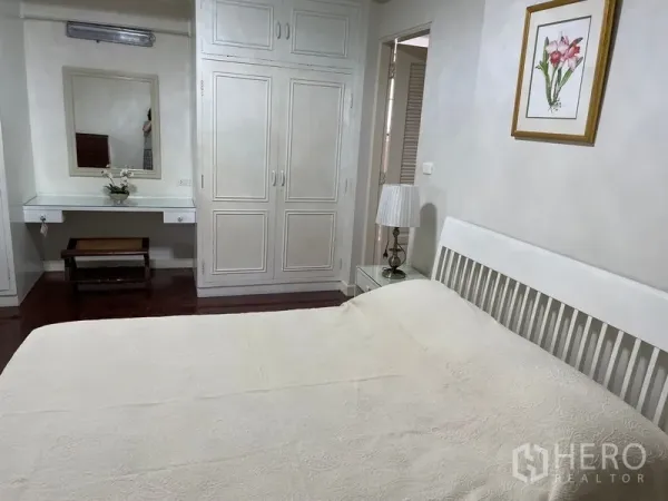 Apartment for rent in Watthana, Bangkok - Cozy bedroom with built-in wardrobe, dressing table and a queen bed.