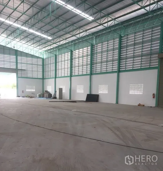 货栈 出租在Samut Prakan - 现代仓库内角度，墙体高挑，配服务门、通风百叶与开阔装卸区。