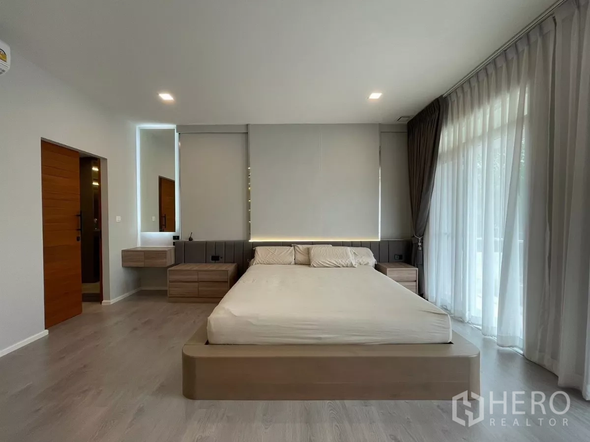 Detached House for rent in Prawet, Bangkok - Master bedroom with platform bed, bedside cabinets and floor-to-ceiling curtains.