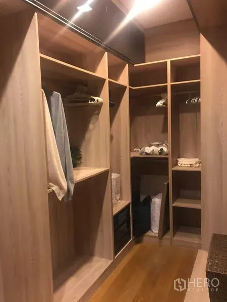 Detached House for rent or sale in Bang Kapi, Bangkok - Walk-in closet with built-in wooden shelves and hanging rails.