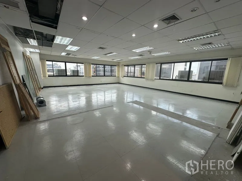 Office Space for rent in Khlong Toei, Bangkok - Corner office shell with ceiling AC vents, recessed lights and city outlook near BTS.