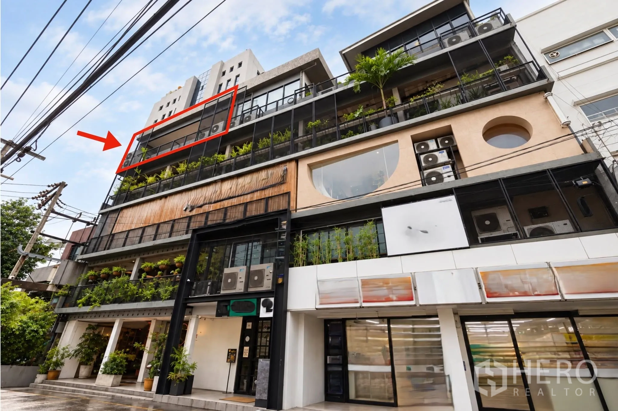 Retail Space for rent in Watthana, Bangkok - Exterior of a modern multi‑level commercial building with glass balconies and greenery.