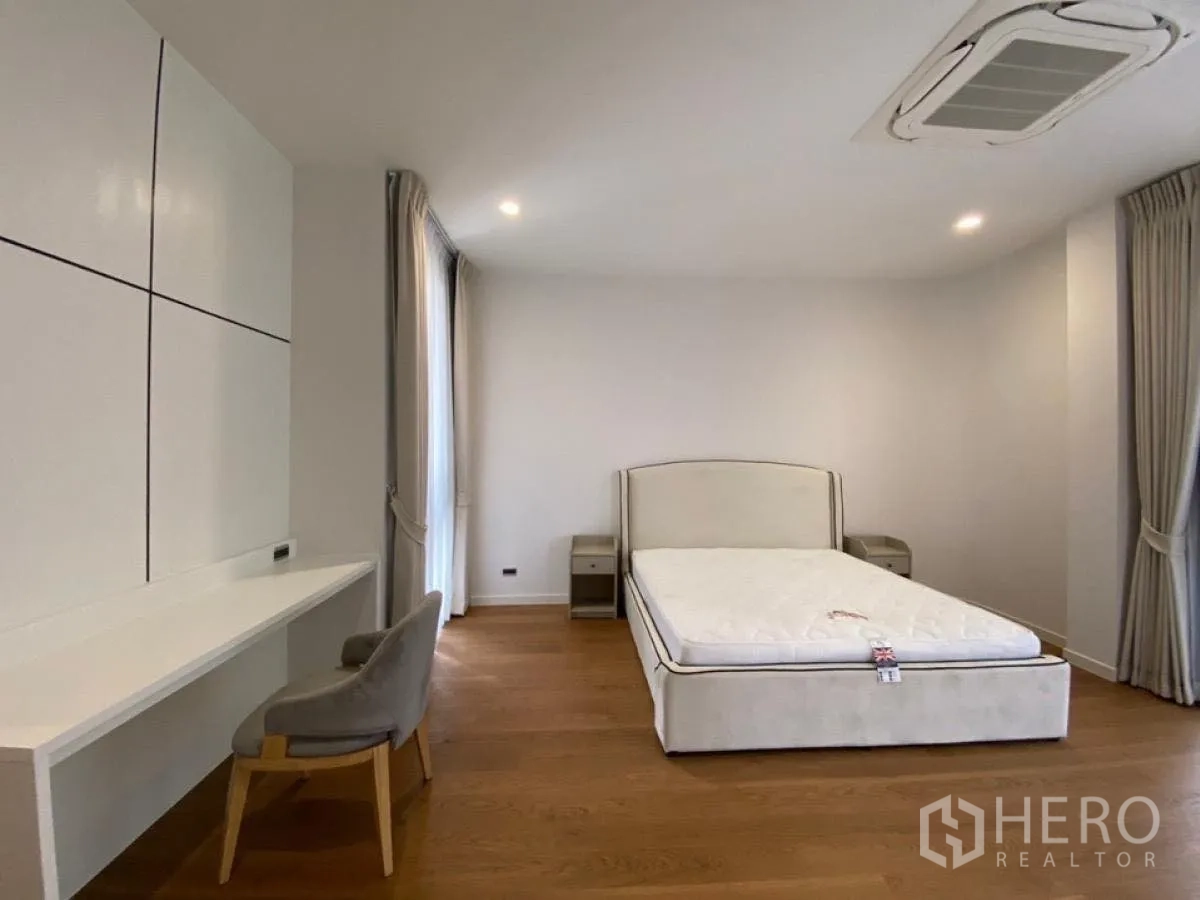 Detached House for rent in Wang Thonglang, Bangkok - Bright bedroom with built-in desk and bed by full-height windows.