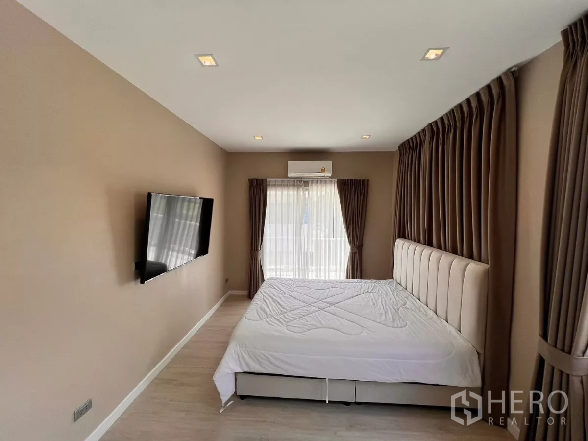 独立式住宅 出租在Lat Krabang, Bangkok - 主卧朝走廊视角，床与全落地窗帘。
