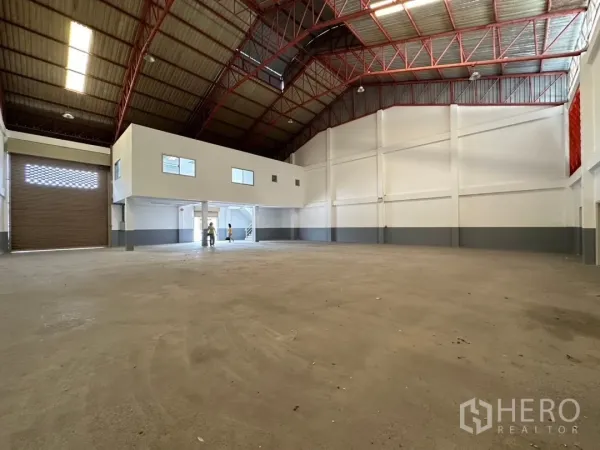 工厂 出租在Bang Sao Thong, Samut Prakan - 仓库内可见宽大的卷闸出入口与清爽装卸空间。