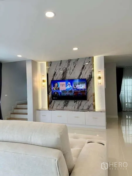 Detached House for rent in Bang Phli, Samut Prakan - Living area with marble feature wall, built-in media cabinet and mounted TV.