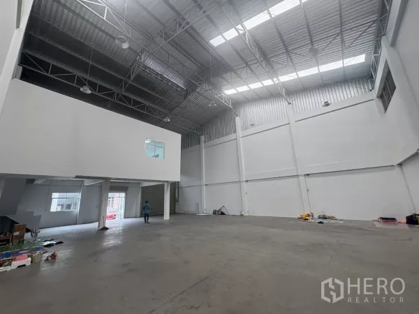 Factory for rent in Phra Samut Chedi, Samut Prakan - Spacious warehouse hall with high steel truss roof and mezzanine office.