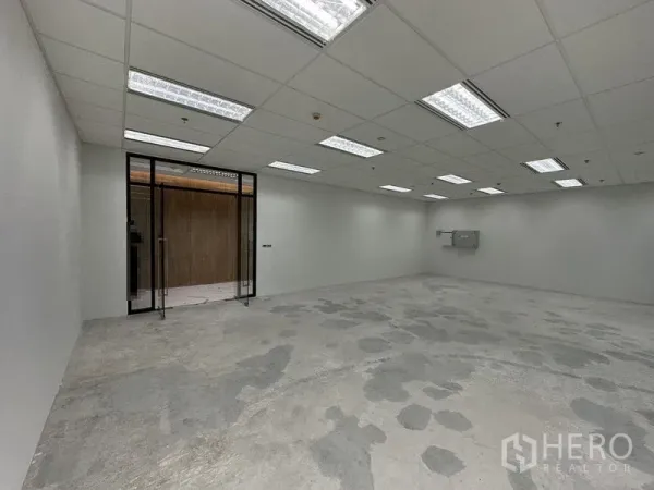 สำนักงาน ให้เช่าในRatchathewi, Bangkok - ภายในออฟฟิศโล่ง มองเห็นประตูกระจกบานคู่ ทางเข้า พื้นคอนกรีต และไฟฝ้ากริดสว่าง