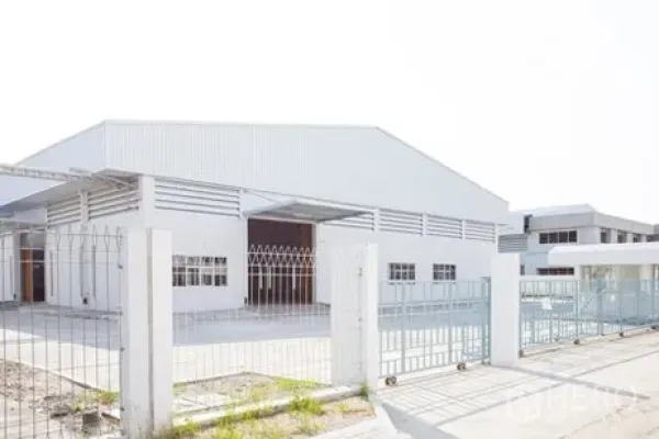 工厂 出租在Bang Pakong, Chachoengsao - 邦帕空白色工业厂房外观，带围栏与金属大门，前方宽阔混凝土车道。